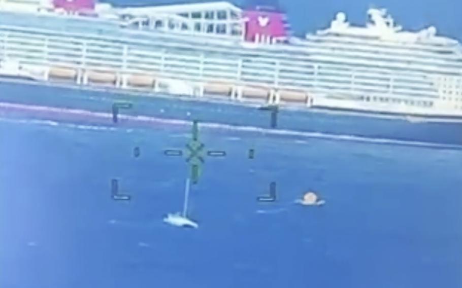 A cruise ship rescuing people from a disabled catamaran 