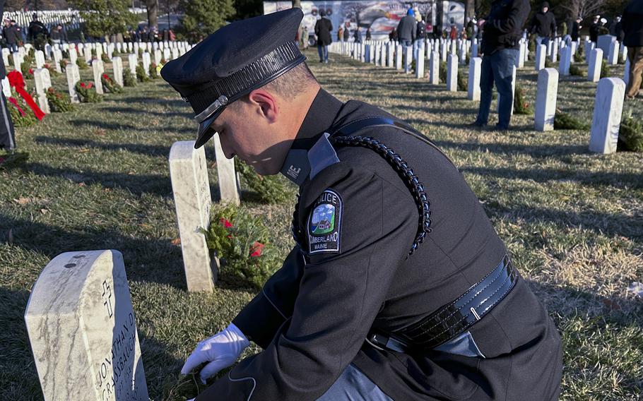 Cumberland, Maine police officer Nicholas D’Ascanio places a wreath during Wreaths Across America at Arlington National Cemetery, Dec. 14, 2024.