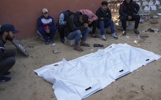 Relatives of a Palestinian killed in overnight Israeli strikes, mourn over his body outside the morgue of Nasser hospital in the Khan Younis refugee camp, southern Gaza Strip, Saturday, Jan. 4, 2025. (AP Photo/Abdel Kareem Hana)