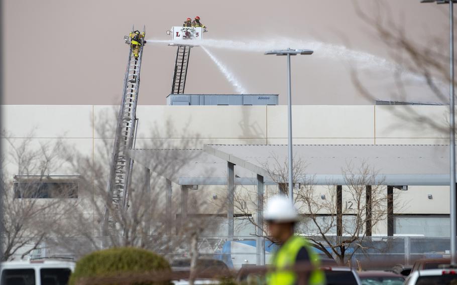 Firefighters spray water on a fire at a building.