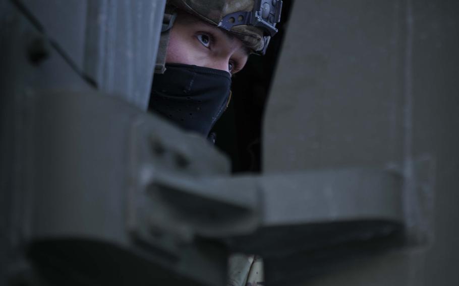 A soldier looks out from the cab of an MLRS.