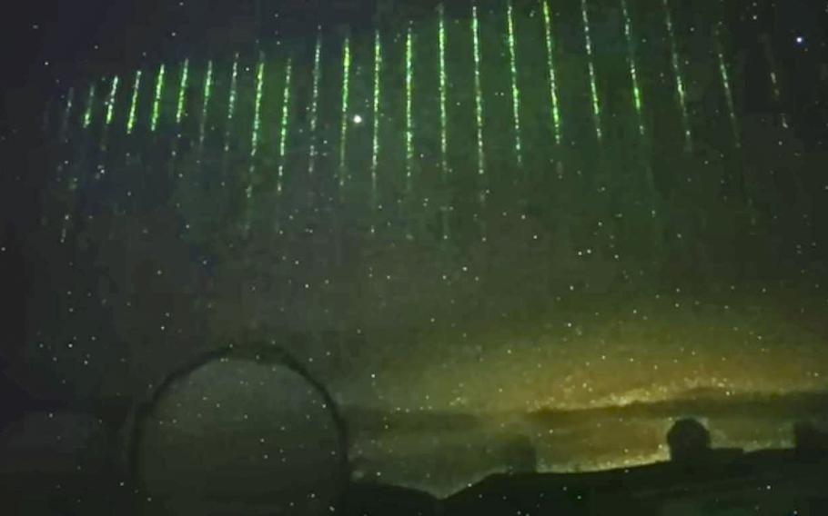 A screen grab of a video posted on Jan. 28, 2023, shows what astronomers are calling green laser lights likely coming from a Chinese satellite and recorded by a camera on Hawaii’s tallest mountain, Mauna Kea, 
