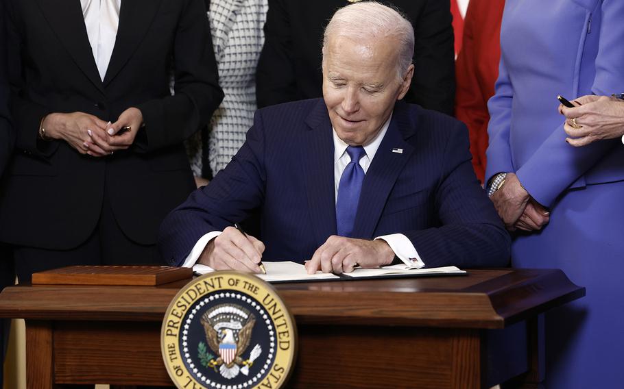 U.S. President Joe Biden signs an executive order on advancing women’s health research and innovation during a Women’s History Month reception in the East Room of the White House on March 18, 2024, in Washington. The event is a part of the Biden administration’s Women’s Health Research initiative.