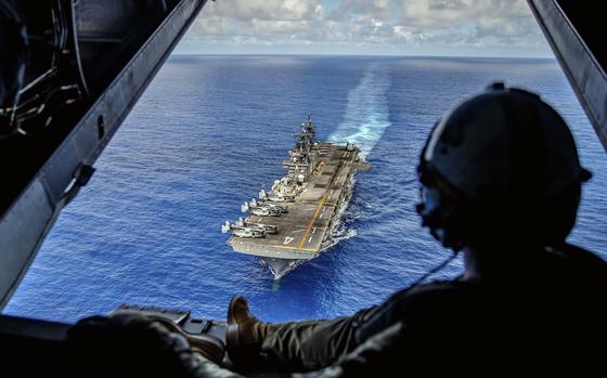 Marine Corps Sgt. Mitchell Parcell, a MV-22 tiltrotor crew chief assigned to the Marine Medium Tiltrotor Squadron, watches the amphibious assault ship USS Boxer in the Luzon Strait, Oct. 8, 2024.