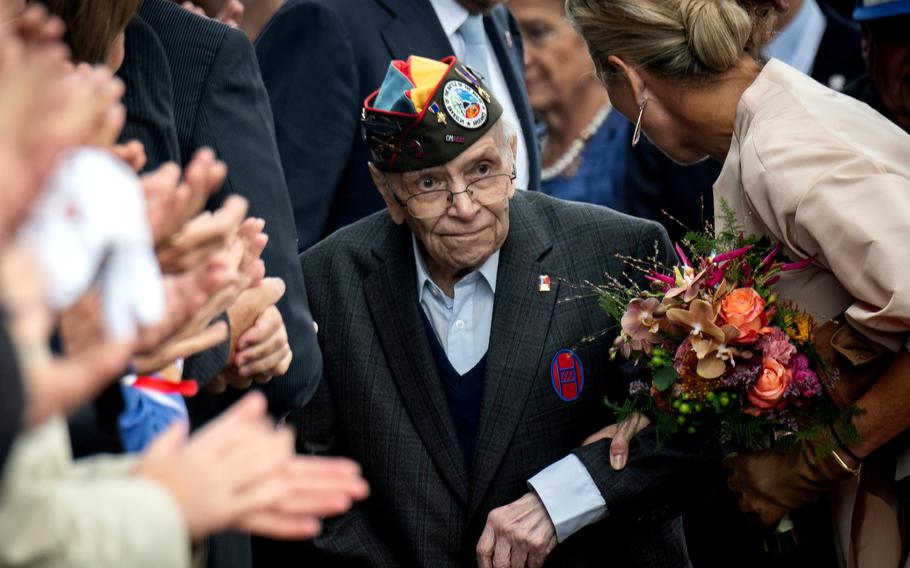 Queen Maxima of the Netherlands escorts World War II veteran Kenneth Thayer, 99, into a ceremony