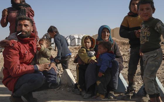 Internally displaced people sit in a camp in Tabqa city, Raqqa governorate, northern Syria, on Wednesday, Dec. 4, 2024. Thousands of Kurdish families displaced from Aleppo and Tel Rifaat have ended up in temporary shelters and on the streets in Kurdish-controlled areas of Tabqa city. (AP Photo/Hogir El Abdo)