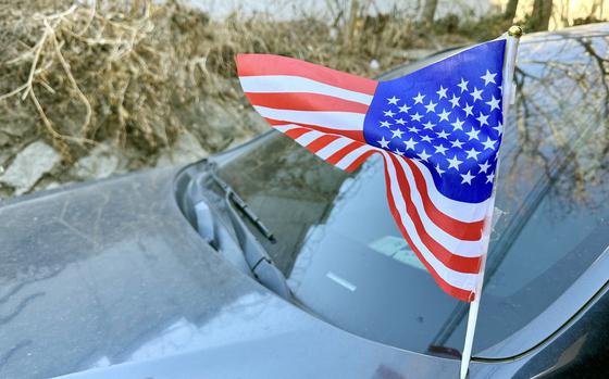 An American flag waves from a car during a demonstration.