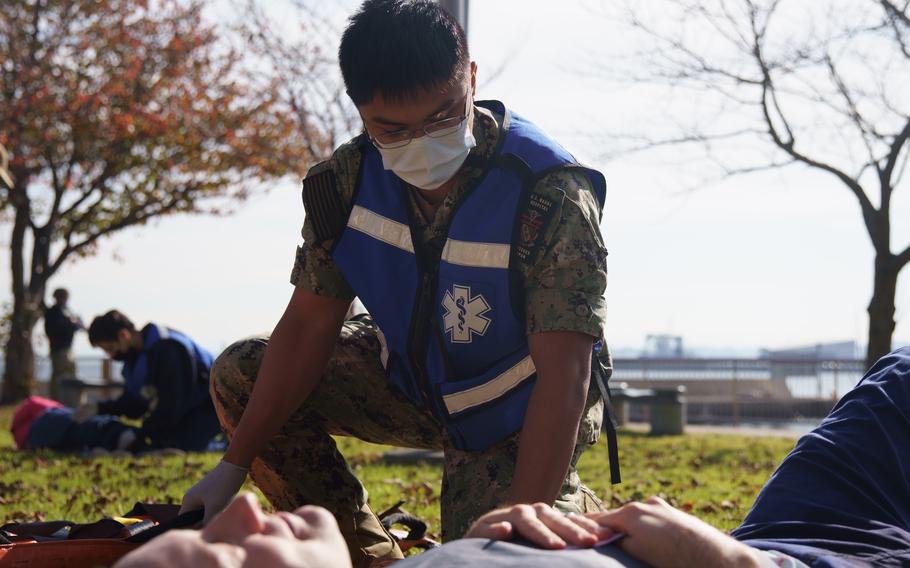 A U.S. Navy sailor tends to a man acting as a victim during a mass casualty drill at Yokosuka Naval Base, Japan, on Nov. 17, 2022. 