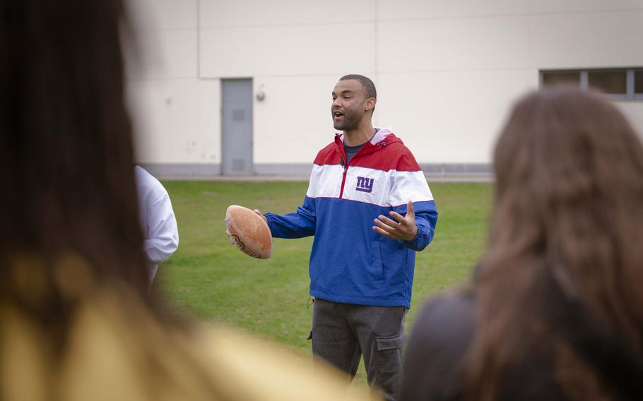 Brandon London, a former wide receiver for the New York Giants, talks to students at Vilseck High School before playing a quick tag football game with the students at Rose Barracks, Germany, Nov. 7, 2024. The visit precedes Sunday’s game against the Carolina Panthers in Munich.