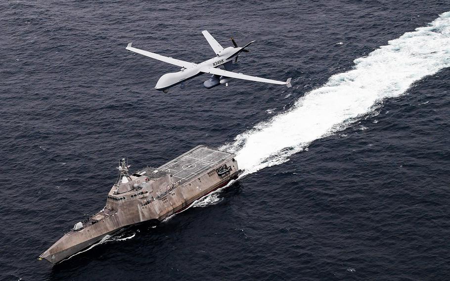 An MQ-9 SeaGuardian unmanned maritime surveillance plane flies over the littoral combat ship USS Coronado in the Pacific Ocean in April 2021. The Navy intends to deploy littoral combat ships to the Middle East for mine countermeasure operations.