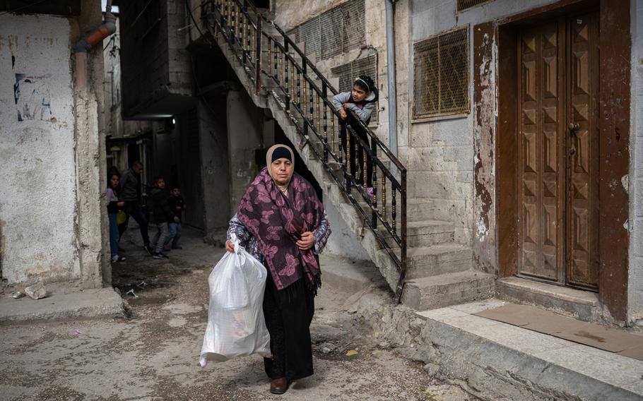 A woman collects empty cans to resell in the Balata refugee camp.