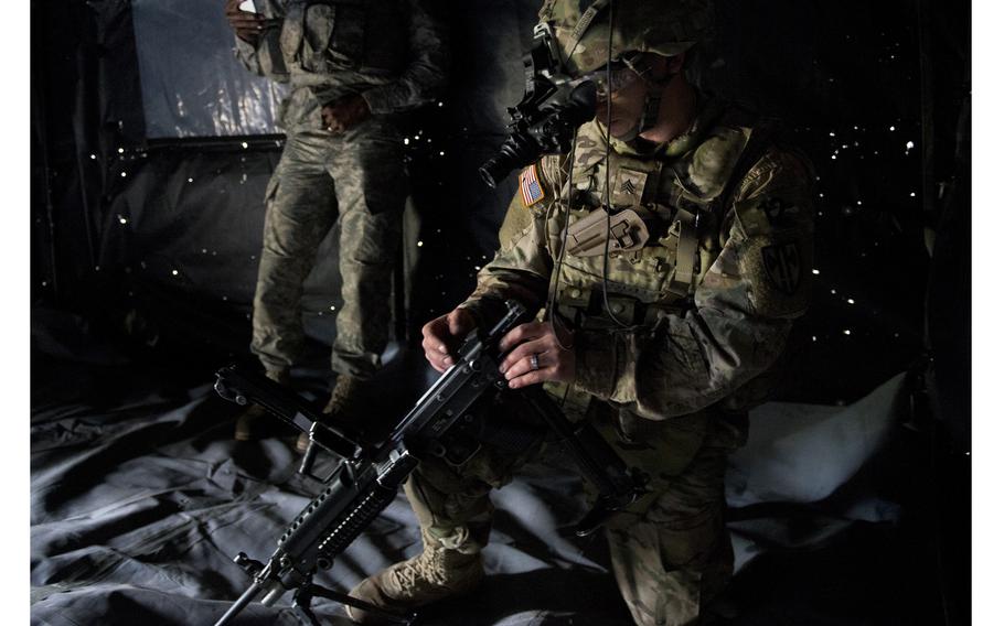 Sgt. Timothy Harris reassembles an M249 Squad Automatic Weapon wearing night-vision goggles