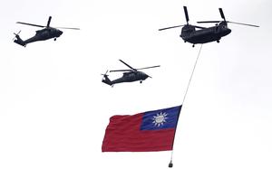 FILE - Helicopters fly over with Taiwan national flag during an inauguration celebration of Taiwan's President Lai Ching-te in Taipei, Taiwan, on May 20, 2024. (AP Photo/Chiang Ying-ying, File)