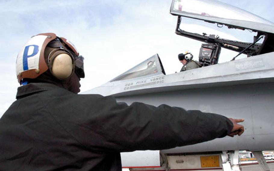 Navy plane captains, usually the youngest personnel in the squadron, serve as the liaison between the pilot and plane and the ground crew. They wash the plane, fuel it and take it through safety checks and inspections. It doesn’t move until the plane captain says so, said one pilot. Here, a plane captain directs the pilot through a startup sequence before a flight.