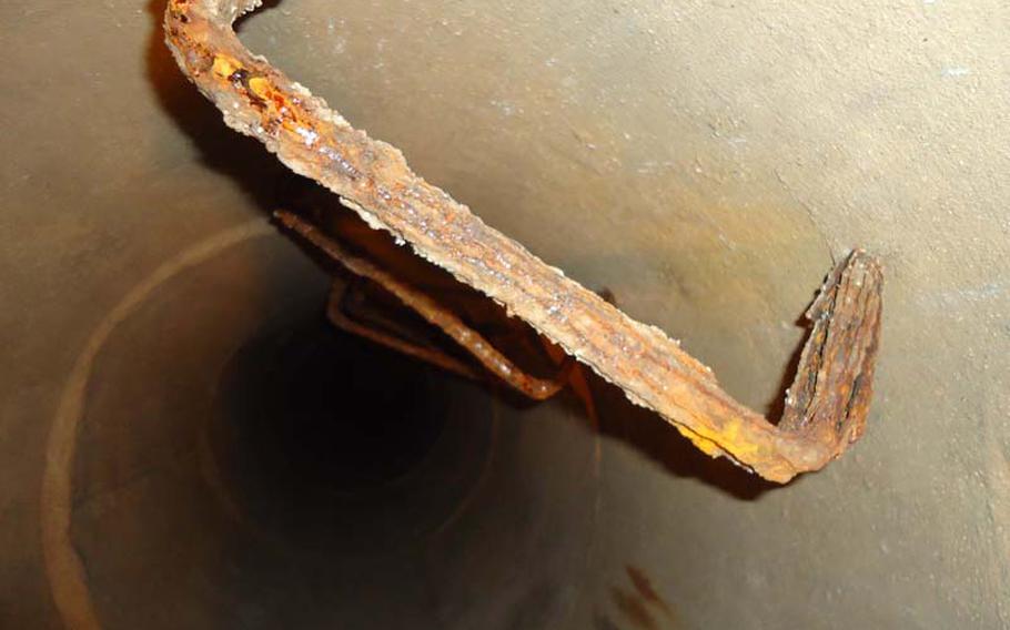 In one of the air-raid shelters's hallways is a rusted ladder and a tube that leads through darkness to the surface for air. 