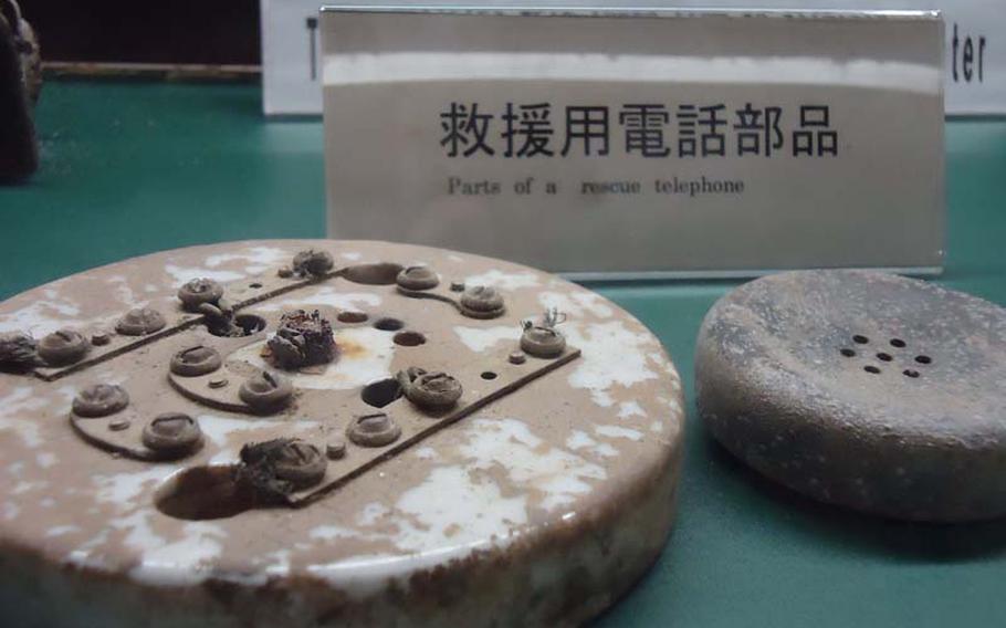 In a display case in one of the Tateyama Air-raid Shelter's empty rooms, lies the pieces of one of the phones used to call for help after the atomic bomb was dropped on Nagasaki by the U.S. on Aug. 9, 1945. The artifacts were unearthed many years later.