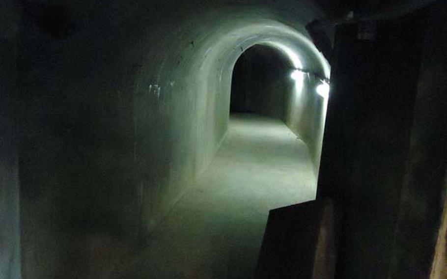 A dark and desolate corridor in the Tateyama Air-raid Shelter and a bashed in door. The shelter is one of Nagasaki's most historically significant, yet largely forgotten, sites and protected important Japanese officials as the atomic bomb devastated the city around them on Aug. 9, 1945. It was from this shelter that initial relief efforts were coordinated and updates were sent to Tokyo. 