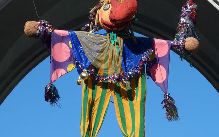 A colorful figure hangs from the Karlstor in Munich. Starting here, the city’s main pedestrian area is a party zone during Fasching.