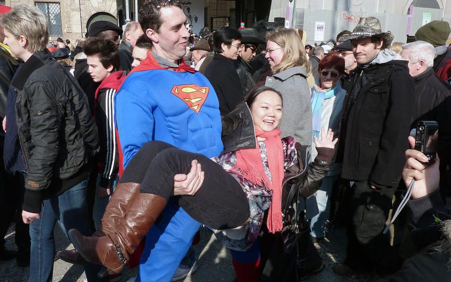 Her hero? The Man of Steel doesn't  have to be more powerful than a locomotive to hold this tourist as she poses for a photo during Fasching celebrations in 2010.