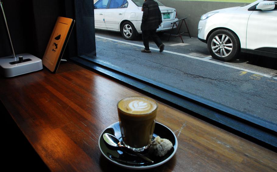 In addition to its small menu of coffees and teas, Botton coffee shop in the Seoul neighborhood of Itaewon offers vegan and regular desserts. Shown here are a flat white, an espresso and milk drink similar to a cappuccino, and a vegan coconut and chocolate chip cookie.