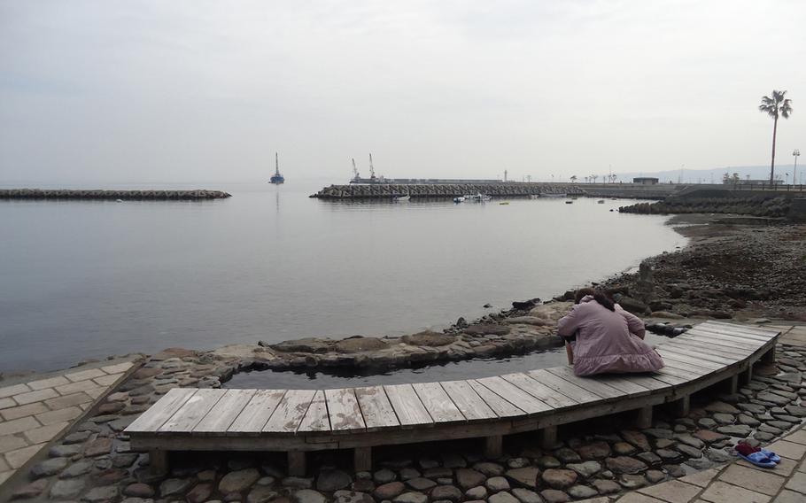 A Japanese woman finds solace in the free foot bath at Beppu Kaihin Sunayu in Beppu, Japan.