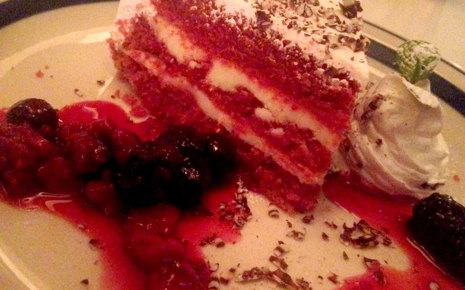 The red velvet cake at MOJA in the House is lined with a cheesecake crust in the center and covered by berries, frosting, and a sweet syrup to add a bit of punch to the dish.