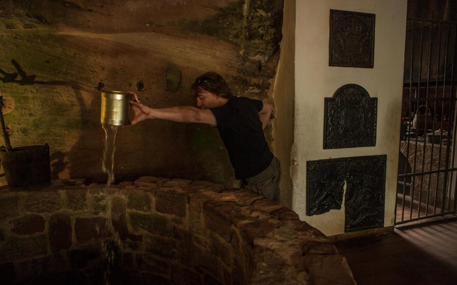 A tour guide at Burg Berwartstein pours water down the castle's well to illustrate its depth - some 320 feet. The Medieval castle was destroyed by fire in the 1500s  but was rebuilt after World War II. It is the only occupied castle in the region.