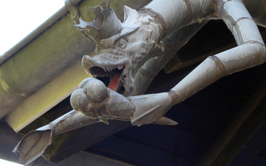 A gargoyle enjoys an ice cream cone on the roof of a Seligenstadt, Germany, ice cream parlor.