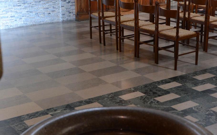 The reflection of a stained glass window appears in a holy water basin as a friar makes his way into the church at the Sanctuary of Castelmonte, which is situated near Udine, Italy.