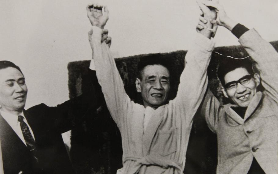 Cpl. Shoichi Yokoi, center, who held out in the remote jungle of Guam for 28 years after the end of World War II, raises his hands with two other former holdouts of the Japanese army on July 30, 1972, in this photo displayed at the Pacific War Museum, Guam.