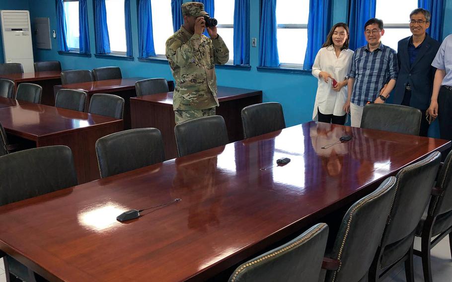 A visiting U.S. soldier photographs the North Korean side of the conference room where authorities from North and South Korea sometimes meet in the Demilitarized Zone, May 29, 2019.