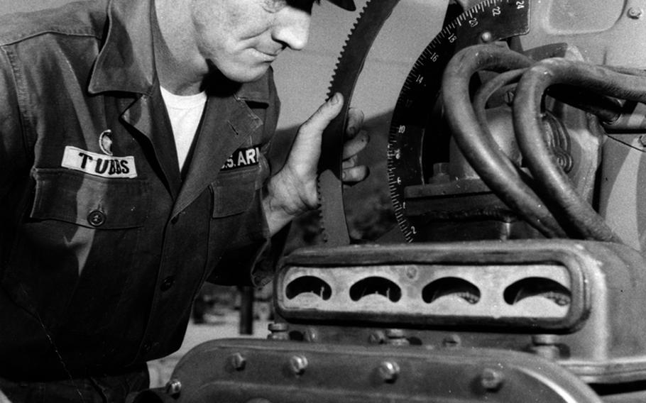 Chief of Section Sgt. Merlin C. Tubbs sets elevation on the huge searchlight. The lights can burn for 1 hour and 45 minutes before their carbon sputters out. The carbon electrode can be replaced in 3 to 4 minutes.