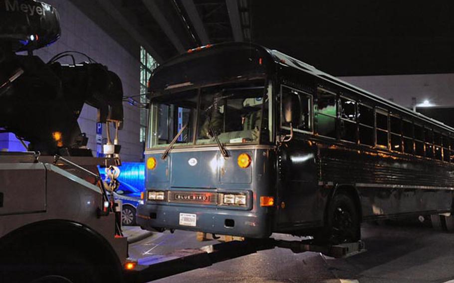 A U.S. Air Force bus is towed from in front of Frankfurt International Airport's Terminal 2. On Wednesday afternoon a gunman shot four Americas, killing two. According to German police, the bus was to be towed to a hall on airport grounds for further investigation.