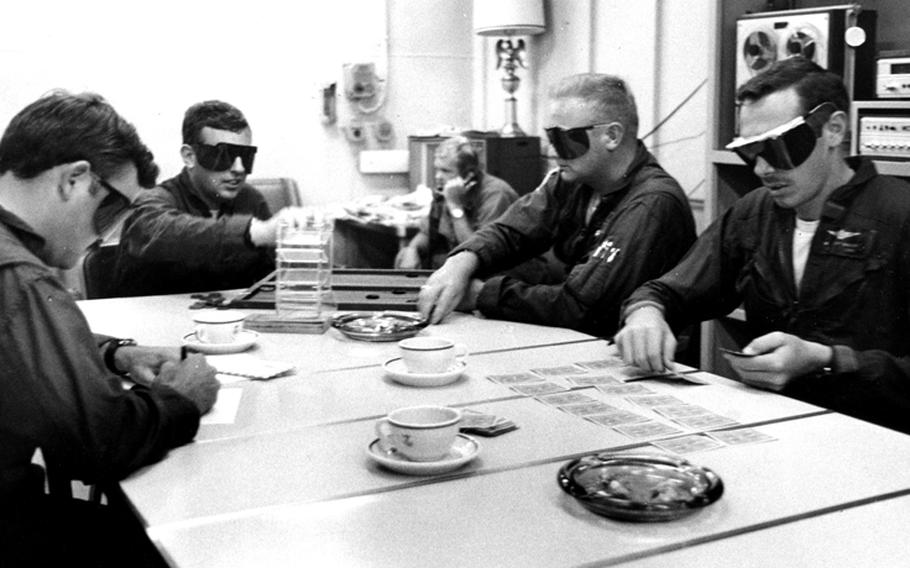 pilots from Helicopter Attack Squadron (Light) 3 wear red goggles to keep their eyes conditioned for night flying.