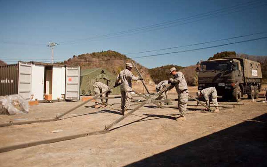 Soldiers from Logistics Task Force 35 work to construct a second shower unit near the Ono Civic Center in Higashi Matsushima, Japan. The units contain 12 showers and six sinks.