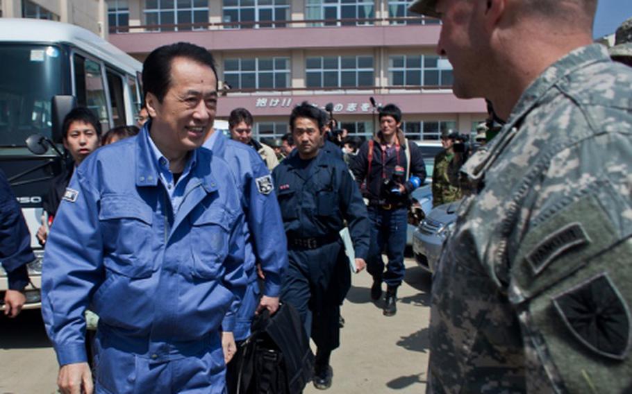 Japan Prime Minister Naoto Kan approaches Army Col. Lance Koenig, commander of Joint Logistics Task Force 10, during his visit to Ishinomaki Commercial High School shelter in Ishinomaki, Japan. Soldiers and Marines from the task force have been working to clean up the school grounds and were thanked by Kan for their efforts.
