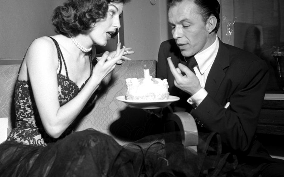 Newlyweds Frank Sinatra and Ava Gardner sample Sinatra's 34th birthday cake backstage at Wiesbaden.