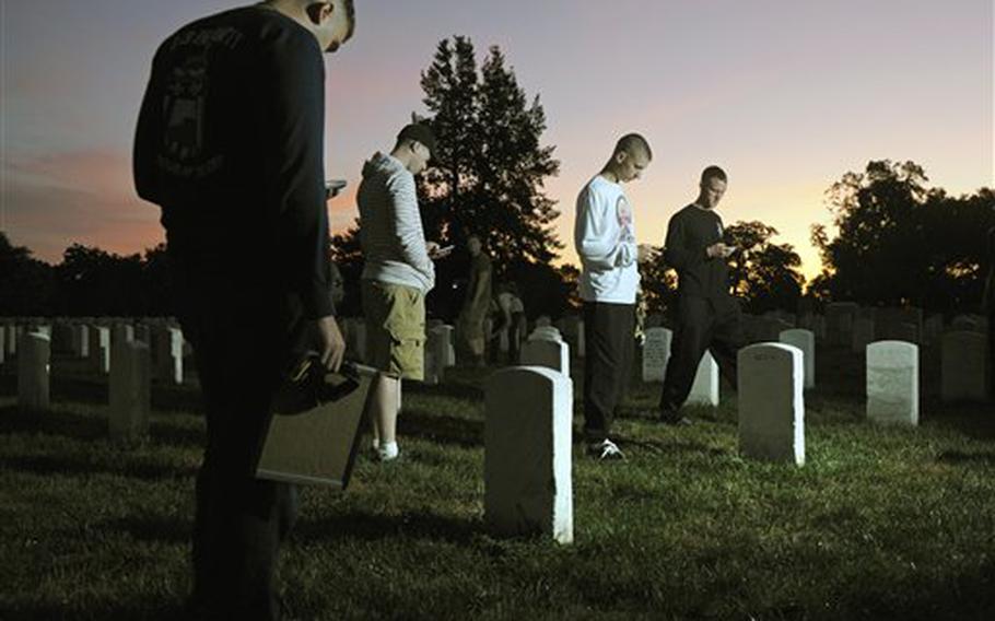 The sun rises over Section 15 as soldiers from the Army Old Guard use iPhones to photograph headstones at Arlington National Cemetery in Virginia on Aug. 24, 2011.
