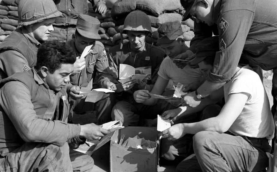 Members of Headquarters Company, 3d Battalion, 180th Infantry Regiment, help Pvt. Anthony H. Obert (fourth from left), Cincinnati, read the thousands of letters he has received from the States after his name was broadcast by a radio disc jockey. Helping the eye-weary Obert with his reading duties are (left to right) Pfc. Emiliano Ortiz, San Antonio; Sgt. William E. Stephenson, Waynesboro, Va.; Pfc. Ralph E. Mosley, Cleveland; Obert; Cpl. Thomas Schwaab, Baltimore; Sgt. Robert Hamilton, St. Petersburg, Fla., and Pfc. Richard Shank, Danville, Ill.