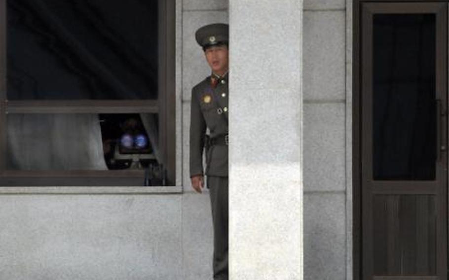 A North Korean guard peers out from behind a granite pillar in  to observe U.S. servicemembers during a tour of the Korean Demilitarized Zone in July 2008. North Korea is finding it harder to keep information from its people, U.S. special envoy Ambassador Robert King said Thursday.