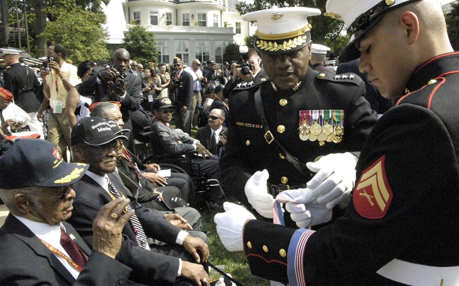 Lt. Gen. Willie Williams reaches for a bronze replica of the Congressional Gold Medal, which was presented to approximately 400 Montford Point Marines at the Marine Barracks in Washington, D.C., on Thursday, June 28, 2012.