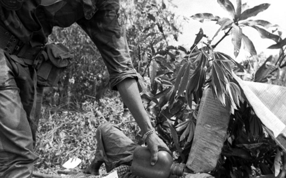 A South Vietnamese marine gives a prisoner a drink of water.