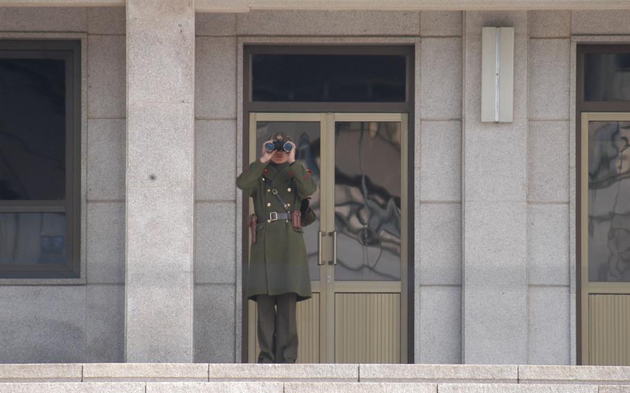 A North Korean soldier surveys the scene on the South Korea side of the Military Demarcation Line on March 13, 2013, at the Joint Security Area of the Demilitarized Zone.

