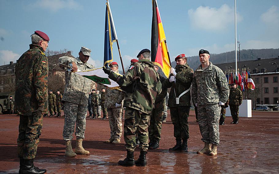 U.S. Army Lt. Gen. John W. Morgan III, commander of NATO's Headquarters Allied Force Command Heidelberg, rolls up his unit's flag before a final casing of the colors to mark the unit's deactivation Thursday in Heidelberg, Germany. 
