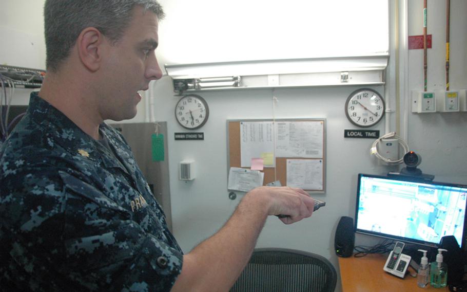 Navy Lt. Commander James Prahl, an ER doctor at U.S. Naval Hospital Guam, turns on a video monitoring feed that connects his patients in Guam with doctors at Tripler Army Medical Center in Hawaii. The teleheatlh suite gives patients on the remote U.S. island territory more options when they need specialty care. 