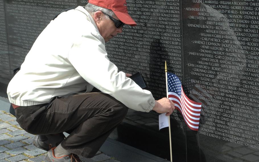 A man pauses to fix an American flag that had fallen over at the Vietnam Veterans Memorial in Washington, D.C. on March 29, 2013, the 40th anniversary of the day the last U.S. combat troops left Vietnam.