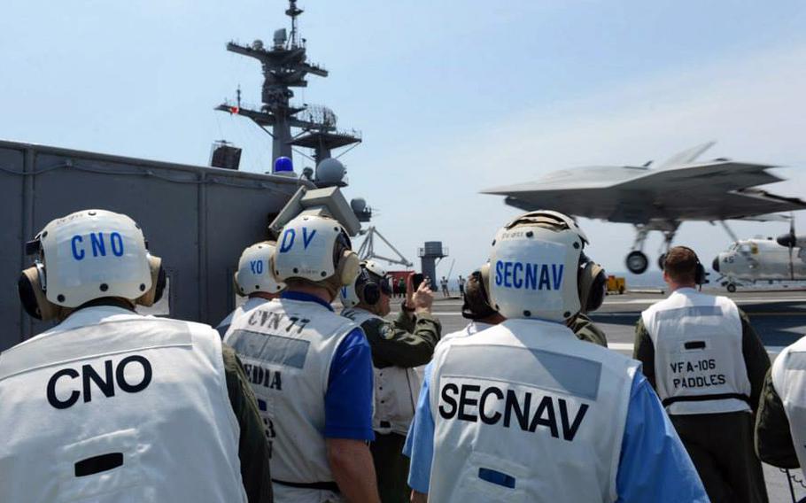 Chief of Naval Operations (CNO) Adm. Jonathan Greenert, left, and Secretary of the Navy (SECNAV) Ray Mabus observe an X-47B drone make the historic first unmanned aircraft landing at sea from the flight deck of the USS George H.W. Bush aircraft carrier July 10, 2013.