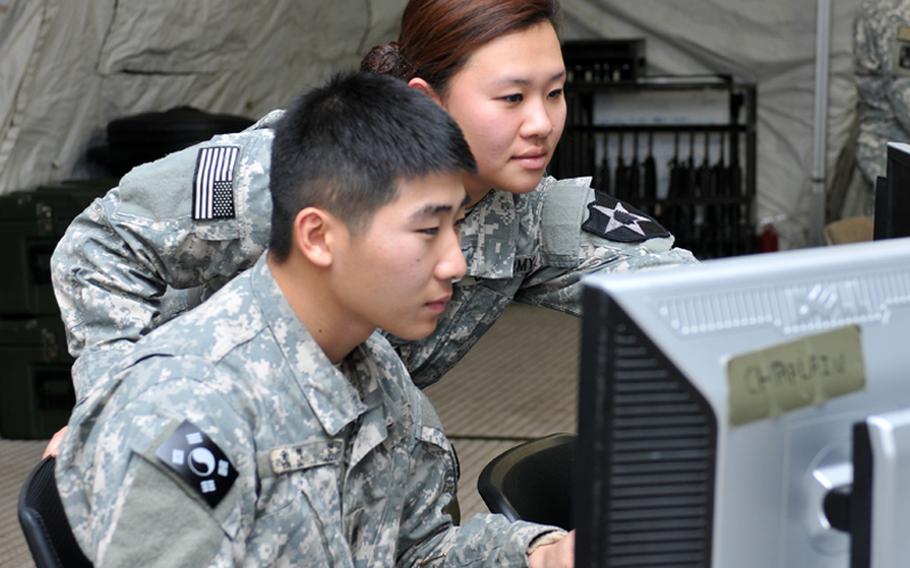 U.S. Army Pfc. Kayla Shin and KATUSA Cpl. Yoon Duk, both of the 2ID chaplain office, research information during the Warpath III exercise at Camp Mobile, South Korea, on Dec. 12, 2013.