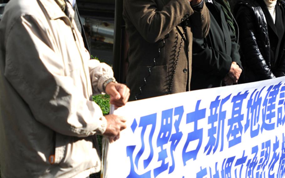 Protesters hold a banner outside the Naha District courts Wednesday, Jan. 15, 2014. The group is supporting a lawsuit that would stop construction of a new air field on Marine Corps Base Camp Schwab. 