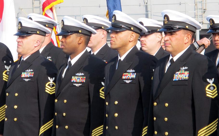 The crew of the Whidbey Island-class amphibious dock landing ship USS Ashland watches intently as executive officer Cmdr. Douglas Patterson takes command from outgoing skipper Cmdr. John Barnett during a change of command ceremony at Sasebo Naval Base in southern Japan on Friday, Jan. 17, 2014.